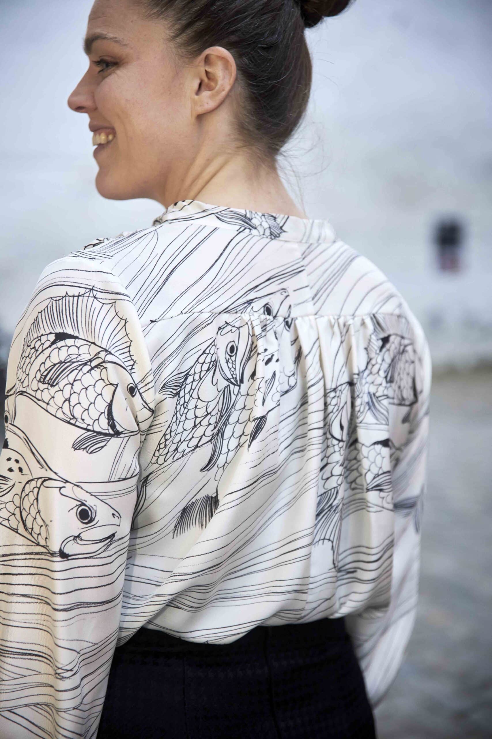 Model i silkebluse bagfra